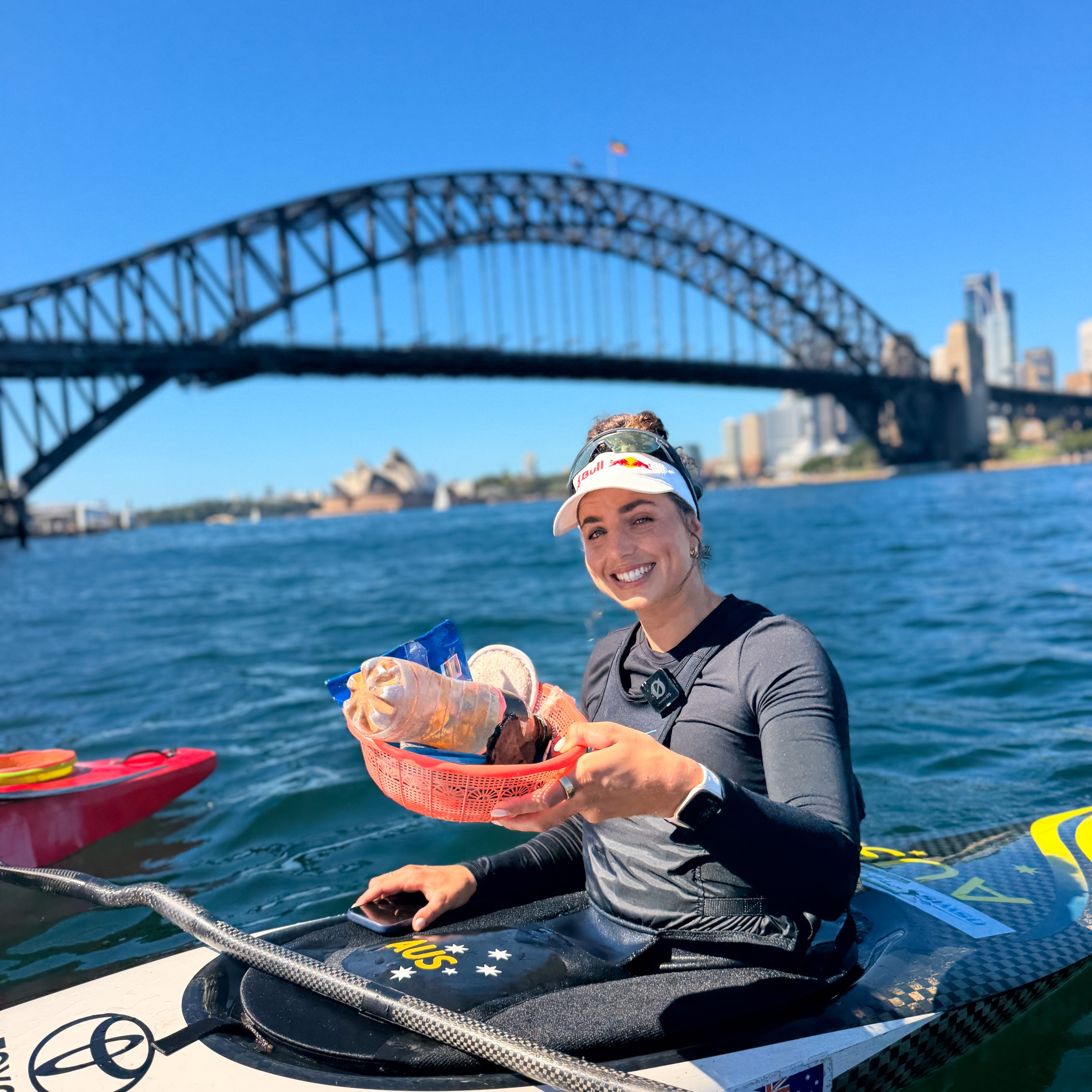 Olympic gold medallist Jess Fox kayaking under the Sydney Harbour Bridge during a clean-up paddle with Sydney By Kayak.