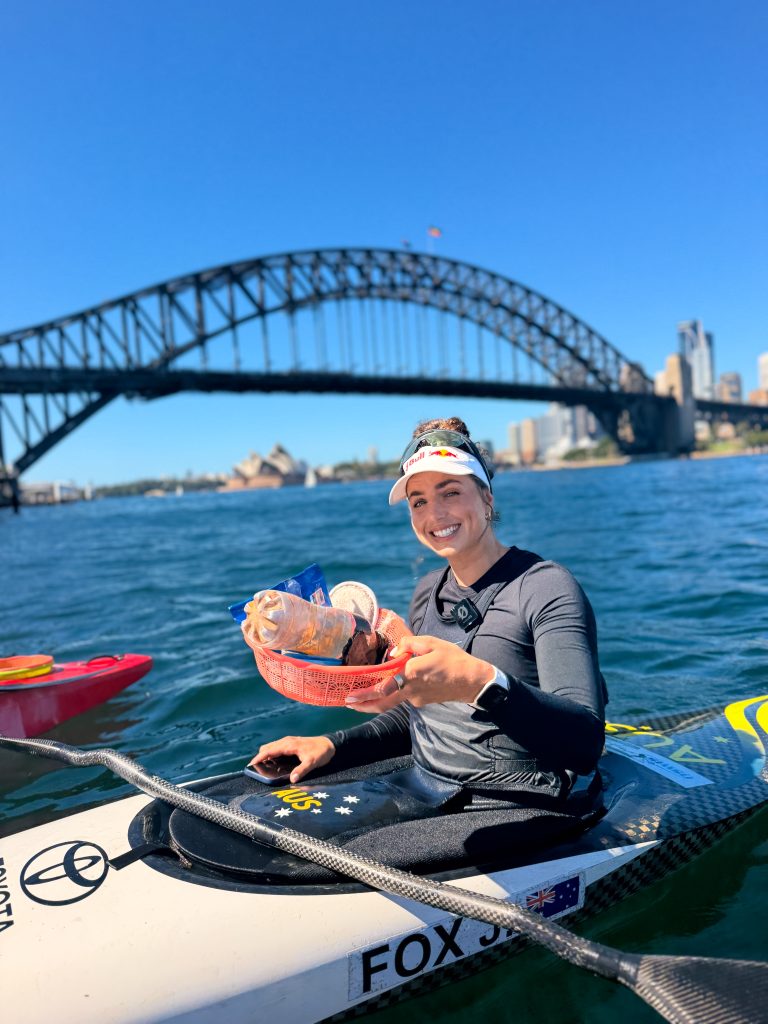 Olympic gold medallist Jess Fox kayaking under the Sydney Harbour Bridge during a clean-up paddle with Sydney By Kayak.