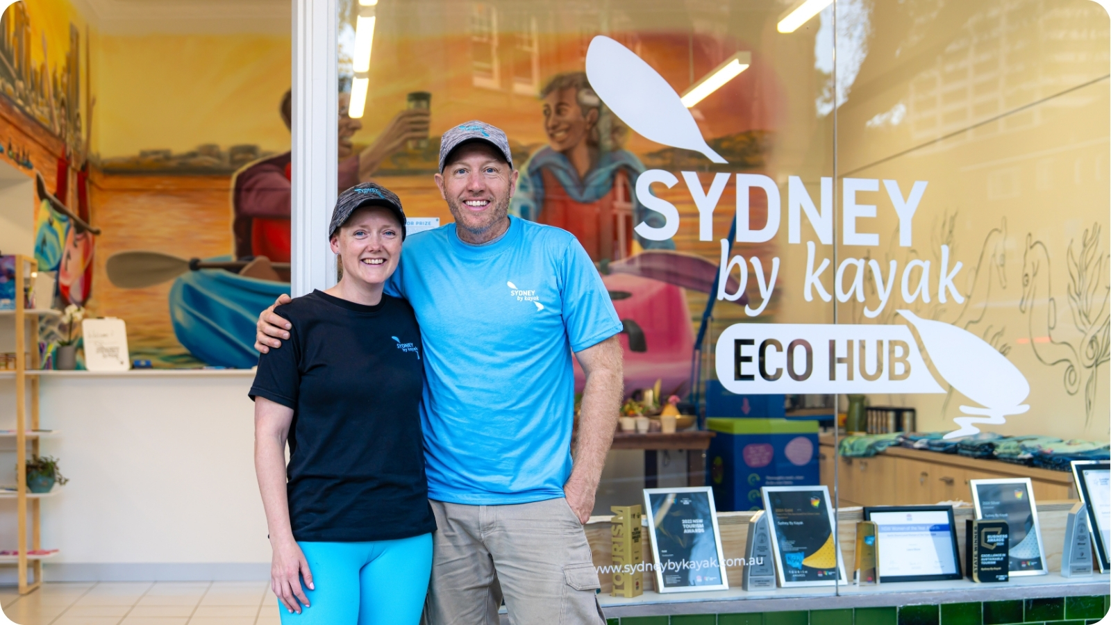 Laura and Ben smiling outside the Sydney By Kayak Eco Hub.