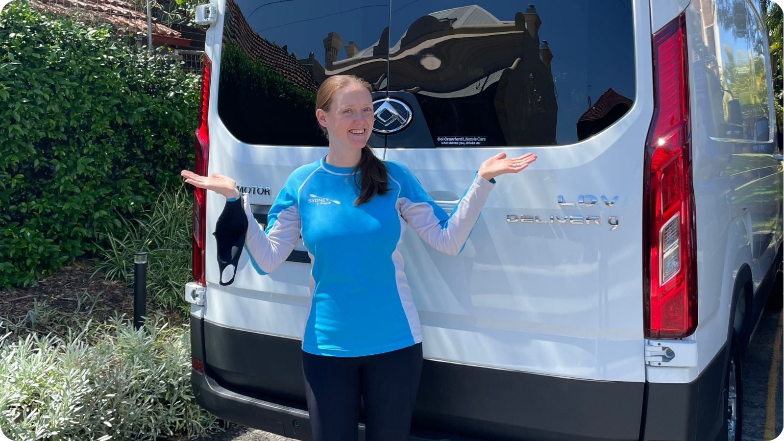A guide gesturing beside the Sydney By Kayak van parked near the Lavender Bay boat ramp.